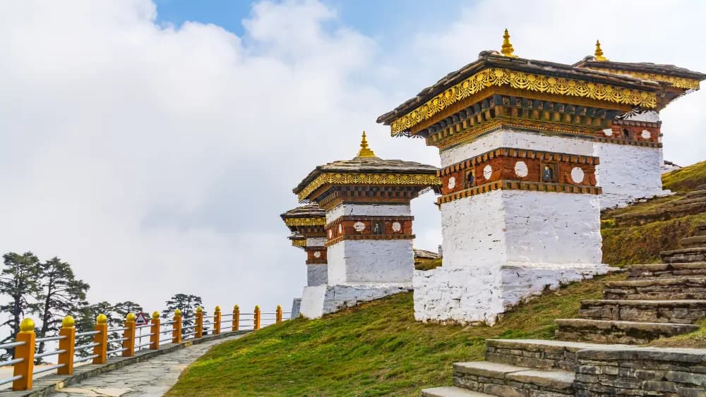 White memorial chortens with golden spires on the hillside at Dochula Pass, Bhutan