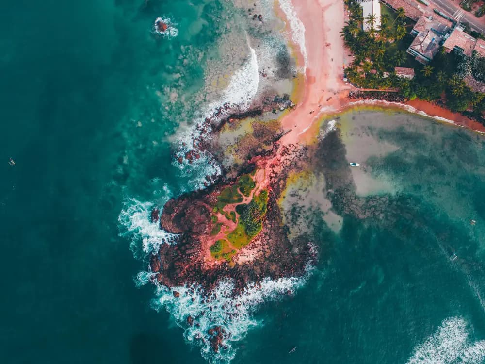 Aerial view of a rocky coastline and turquoise sea in Sri Lanka